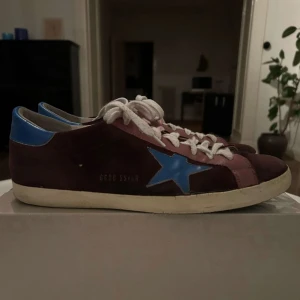 Golden Goose skor - Ett par vinröda, unika och snygga Golden goose skor som är perfekta nu inför sommaren! Dem är smått färgade vid skosnörena, men annars är dem i super skick! Autentisk box tillkommer, hör av er vid frågor/ funderingar! (Säljer åt en kompis!)