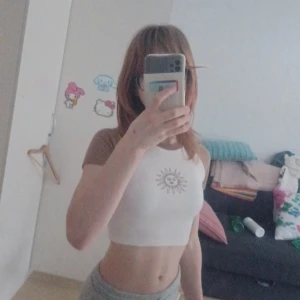 Vit crop top - Snygg crop top från shein med en brun sol,är från shein teen och sitter ganska tight. Kontakta innan köp!