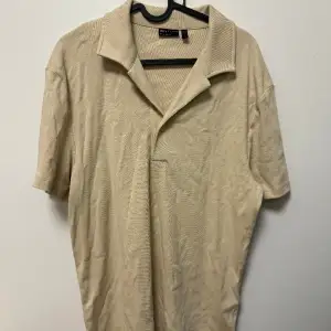 Helt ny polo i beige aktig vit färg i storlek Small säljer för 250kr