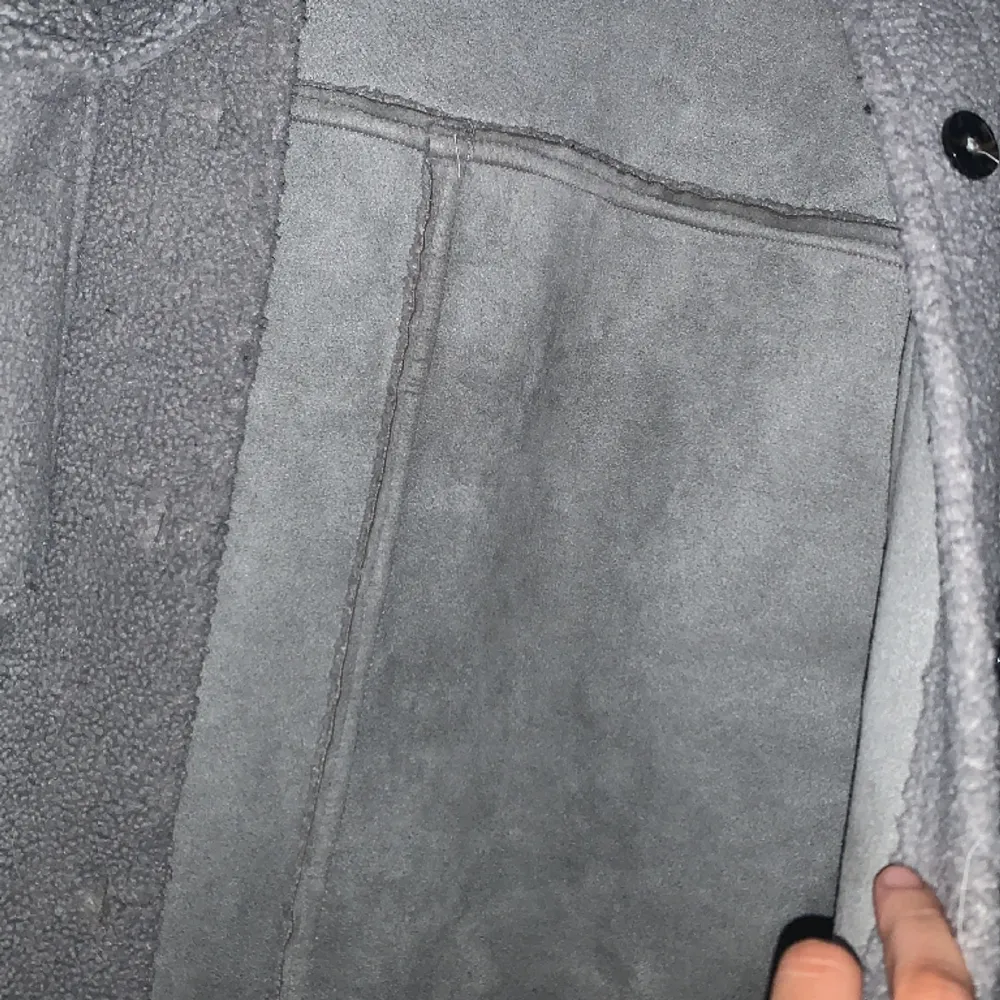 Oversize kappa grå ull utan på och mocka på insidan. Den håller en varm. Något enstaka cigarett märke på nedre delen. Jackor.
