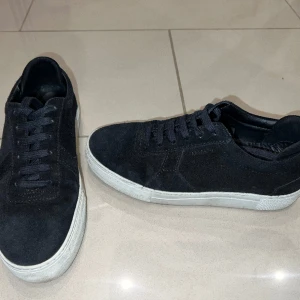Arigato sneakers  - Knappt använda, är i nytt skick. Säljer pga har liknande. Svarta mocka sneakers som passar med allt! Storlek 37, kunder får med inlägg vilket passar 36,5 och skorna utan inlägg passar 37,5. Pris kan diskuteras. Inköpspris 2600kr