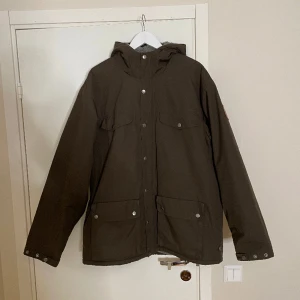 Fjällräven Greenland Jacka - Fin fjällräven greenland jacka som jag säljer då den inte kommit till användning. Skicket är nästintill nytt, då den mest har hängt i ett år. Storlek XL. Färgen är oliv grön och fodret är mörkare grått. Har du frågor kom dm, pris kan diskuteras😄