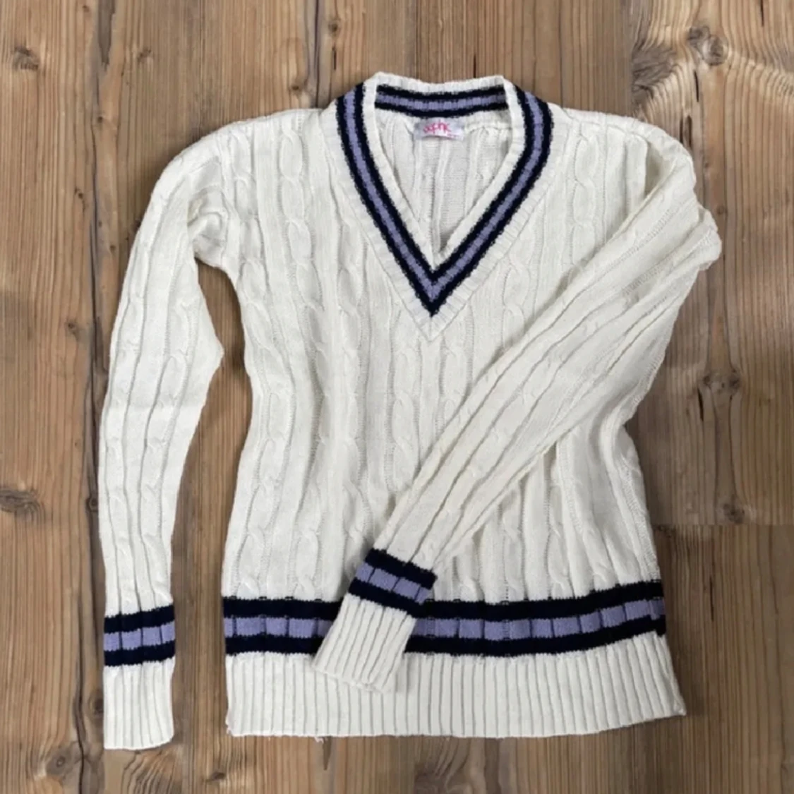 Vit stickad med blåa ränder