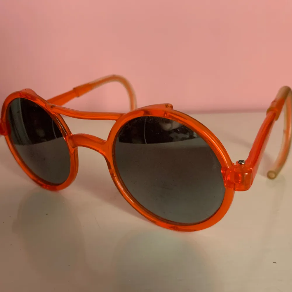Ett par roliga/fula/snygga solglasögon i orange plast, speciella och lite unika och är nog från -80-90-talet.. Övrigt.