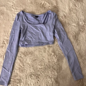 Lila set - Ett lila set, kjolen är över knäna och tröjan är kortare i modellen.