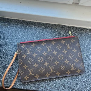 Louis Vuitton neverfull clutch - En LV cloutch, köpt 2021 på en vintage hemsida för 3995kr.  Den är i mycket fint skik. ”Handtaget” på dragkedjan är slitet och det syns på den sista bilden. 