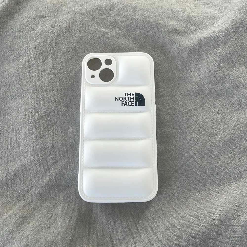 The North Face puffer mobilskal till iPhone 13 finns i både svart och vitt, skriv vilken färg du önskar . Övrigt.