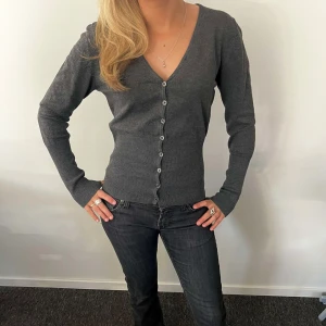 Grå kofta med knappar  - Den är väldigt liten i storleken så skulle säga att den passar S 
