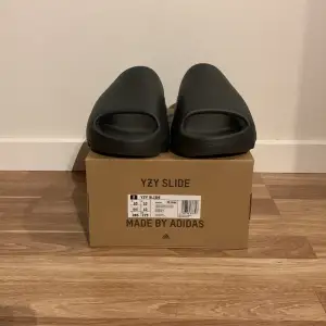 Hej 👋 jag säljer ett par helt nya yezzy slides 👟🔥 i colorwayen dark onyx 😍⚫️köptes via adidas CONFIRMED appen✅ Pris kan diskutera🤝💵✅Det e bara att höra av sig 📞om man har någon fråga eller vill se fler bilder 📸😁✅