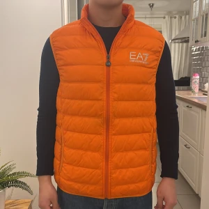 Ea7 väst - Nypris: 1700 och jag säljer den för 550. Mycket bra skick på den. Jag har haft den i 2,5 år men inte alls använt den mycket. Storleken är xl men den sitter mer som S-M. Kvitto och tags finns. Jag är ca 173 och den är för lång på mig.