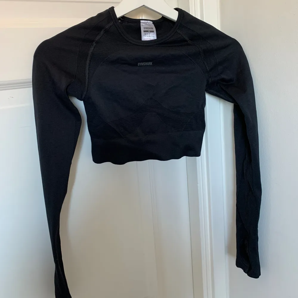 Säljer denna svarta gymshark tröjan då den inte kommer till användning 🤍 jag har använt den ca 3 ggr 🤍 superfin och skön tröja att träna i! Andra bilden är på ryggen 🥰 kom priv för mer info . Toppar.