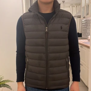 Ralph Lauren väst - En fin Ralph Lauren väst som jag har haft i ca ett år. Passar ca 170-175 cm. Den sitter som slim fit. Skicket är ganska bra förutom några defekter som man kan se om man kollar noggrant. Därav priset, som är 850 kr. Nypriset är ca 2400 kr. 