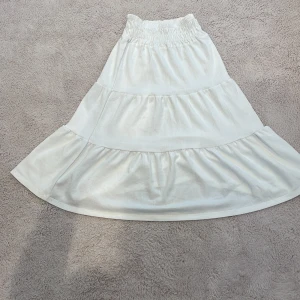 Vit långkjol - Säljer denna superfina långkjol ifrån Gina tricot i storlek 134/140 Kjolen är använd ett fåtal gånger och därmed väldigt bra kvalitet