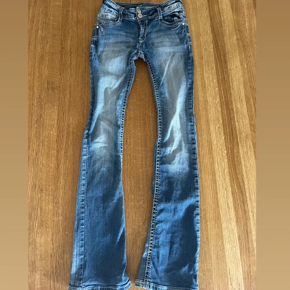 Jeans från märket Wallflower. De är lågmidjade och bootcut, inga defekter. De har fina detaljer längs med benen, midjan och på fickorna. Storlek står ”0” men jag själv har storlek 34/36 eller även 26 och de passar mig fint. NYPRIS 1940kr!!. Jeans & Byxor.