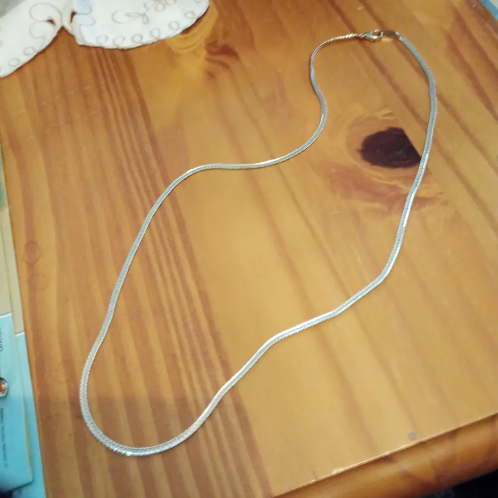 Halsband guldfärgad plätering med stämpel på brickan 18K GP. Kedjan 62 cm lång.. Asusteet.