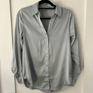 Loose skjorta  - Skjorta med mjukt satin bomull. Lite längre i modellen. Finns knappar så den går att styla på olika sätt. 