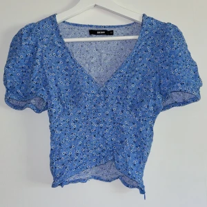 Blommig topp - En söt liten blommig sommartopp! Väldigt fint mönstrad och vacker detalj med knappar fram. Den har en dragkedja i sidan. Inga skavanker!🌸