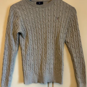 Kabelstickad Gant tröja - Säljer min gråa kabelstickade gant tröja då den inte används. Skicket på tröjan är väldigt bra då den bara är använd ett få tal gånger.  Skriv för fler frågor eller fler bilder.   (köparen står för frakten)