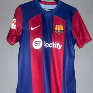 Barcelona 23/24 hemma - Säljer en äkta Barcelona-tröja från säsongen 23/24 med De Jong på ryggen. Som har varit en av Barcelonas bästa mittfältare denna säsong. Köpt på Camp Nou och sparsamt använd.