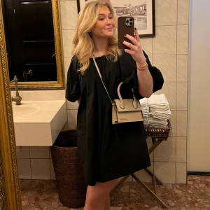 Svart kort klänning  - Svart kort klänning med puffärmar. Fickor som inte är synliga. 