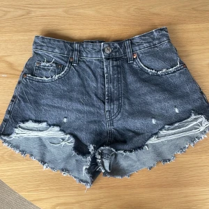 Gråa Zara jeansshorts  - Mid waist Zara shorts som är för små för mig, i fin grå/svart tvätt, fina slitningar+aldrig använda🫶🏻🫶🏻 Midjemåttet: 35cm rakt över💕 Längd: 27cm💕