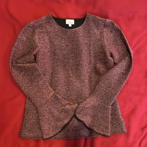 Glittrig tröja - Svart tröja med rosa glitter detaljer. Väldigt fin. Perfekt till födelsedagsfest eller annat. Använd 2-3 gånger bara. Storlek 170 men skulle säga att den är större än 170 då den passar min syster med storlek M. Skriv till mig vid bild på❤️😊
