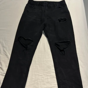Svarta jeans  - Svarta jeans med hål Strl. 1XL Använd 1 gång