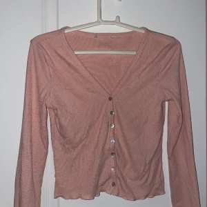 Tröja med knappar fram  - Rosa tröja med knappar. Bra skick. Lapp i rygg bortklippt men det fanns en i tröjan som sa att den var från madlady. Storlek XS. 