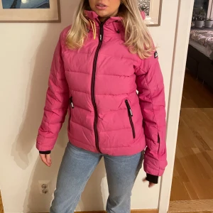 Skidjacka - Jättefin rosa skidjacka som är använd rätt mycket men fortfarande bra skick bara lite missfärning under luvan där av priset, men det syns bara ifall luvan är uppe!!