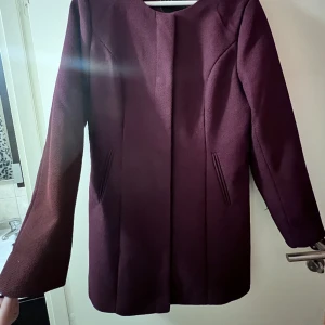 Burgundy kavaj/jacka - Använd men är i god skick.Har ett litet runt märke som är knappt synlig på sidan.