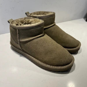 Uggs - Säljer mina ”uggs” för att jag har andra jag använder. Det ser gröna ut i ljuset och det kommer skiftningar av att det är gröna. I dagsljus ser det brunare ut😍 helt nya