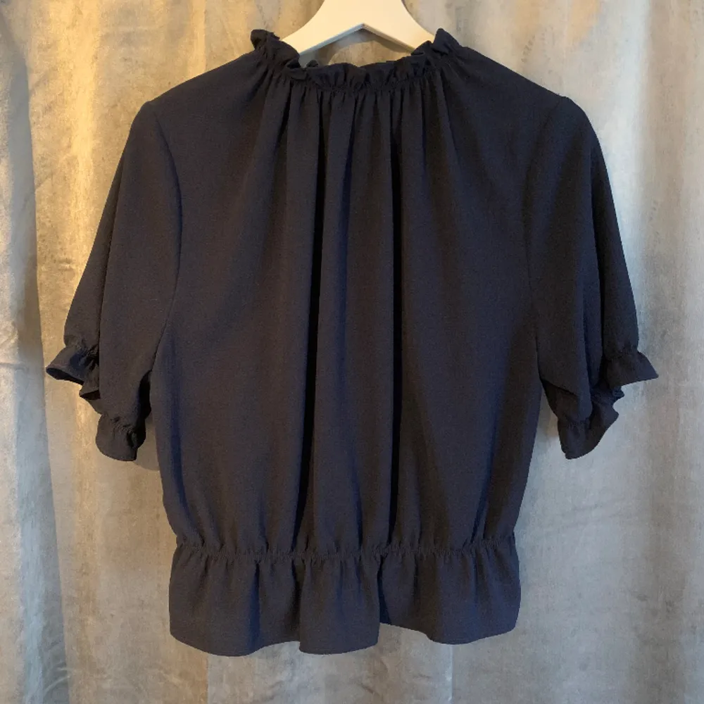 Blus från Gina Tricot i fin marinblå färg. Framhäver midan snyggt. Super fint skick, använd ytterst få gånger. 98% polyester 2% elastan. Blusar.