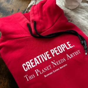 Röd Hoodie med tryck - Röd hoodie med tryck på framsidan och ärmen från Pull&Bear.  Tröjan är skön och lätt, men tyvärr inte helt min stil längre, kan passa bra som tex street wear!