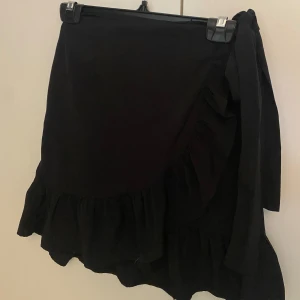 Svart omlottkjol - Säljer nu denna kjol då den inte längre kommer till användning. Jättefin basic kjol som är luftig och sitter perfekt❤️