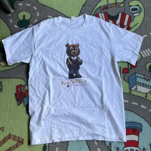 Kanye West tshirt late registration - En Kanye West tshirt med tryck från albumet Late Registration. I nyskick använd och tvättad en gång. Kanske kan behöva stryckas en gång. 🤍🤎 Mått: längd 65cm, bröstbredd 48cm