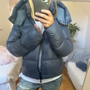 Blå glansig vinterjacka i nyskick - Så så fin och varm vinterjacka❤️ Den är perfekt längd och storlek på mig som är 165! Köpt på miinto för 3000❤️ Slutsåld på hemsidan