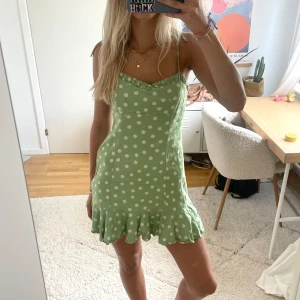 Grön prickig klänning - Så söt prickig volangklänning! Öppen i ryggen, har själv klippt banden och knutit dom💗💗