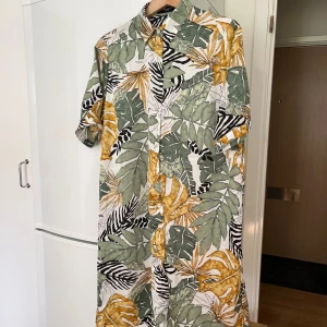 Skjortklänning  - Fint skick. Använd fåtal gånger  knappar helskäggen ner + ett knytskärp En hälla saknas  Storlek xl  101cm från Axel till nederkant 