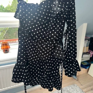 Prickig klänning - Prickig enarmad klänning med prislappen kvar!  Den har ett band runt midjan som du även kan välja att ta av Säljer för att den inte kommer till användning!💘