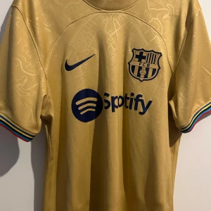 Pedri away shirt 2022/23 Laliga winning season - Barcelona bortaställ från 2022/23 säsongen. Säsongen de vann laliga och ett av pedris bättre säsonger. Tyvärr är den etiketten som bevisar att den är äkta bortklippt. Köpbevis från Unisport på sista sliden dock. Lite pulls men inte så synliga.
