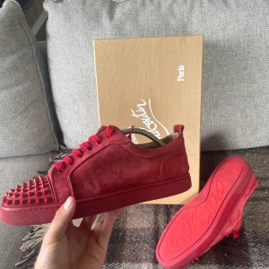 Christian Louboutin Junior Spikes  - Säljer mina röda/vinröda Louboutins nu i storlek 41/42. Bra skick och såklart äkta.  Box, extra spikar, skosnören och kvitto medföljer. 
