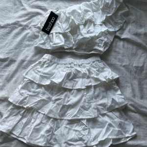 Volang set - Vit set kjol och topp med volanger från boohoo, aldrig använda köpta för ca 500kr säljs för 100 båda tillsammans 