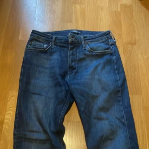 Jack and jones jeans  - Mörkblåa Jack and Jones jeans, passform regular. Bra skick bara minimala defekter nere på benen. W29 L32