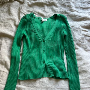 grön långärmad topp - hej💕💕 säljer denna gröna långärmade tröjan från h&m i storlek xs. Man kan knäppa upp knapparna och styla den utifrån det, vilken gör den så snygg! Knappt använd🌸💕