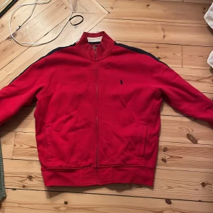 Röd zip-up från Ralph Lauren - Ralph Lauren med vintage känsla!!! Skitnajs röd zip up i något tjockare material. Passar M, står XL på lappen men det stämmer inte alls. 