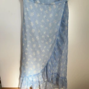Blå långkjol med blommor  - Säljer dennna fina löngkjolen frön vero Moda med blommor och blå färg. Väldigt bra skick och storlek S