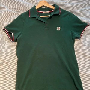 Moncler piké - Mörkgrön piké från Moncler, använt skick och väl omhändertagen. Nypris 3.500:- säljer för 1.500:- 