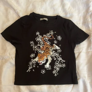 Topp med tryck - Väldigt fin topp med lejontryck köpt från new yorker. Väldigt fint skick, använd få gånger och den är fräsch. Säljer då den är lite för kort för mig.❤️