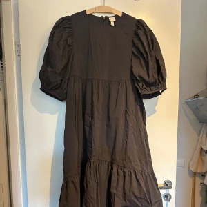 H&m klänning med puffärmar - En brun maxi klänning ifrån h&m med puffärmar 