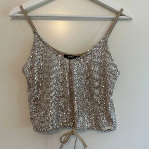 Somrig festlig topp - En elegant champagne färgad topp som är helt ny.